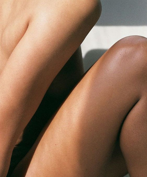 Une femme assise avec les jambes et épaules dénudées.